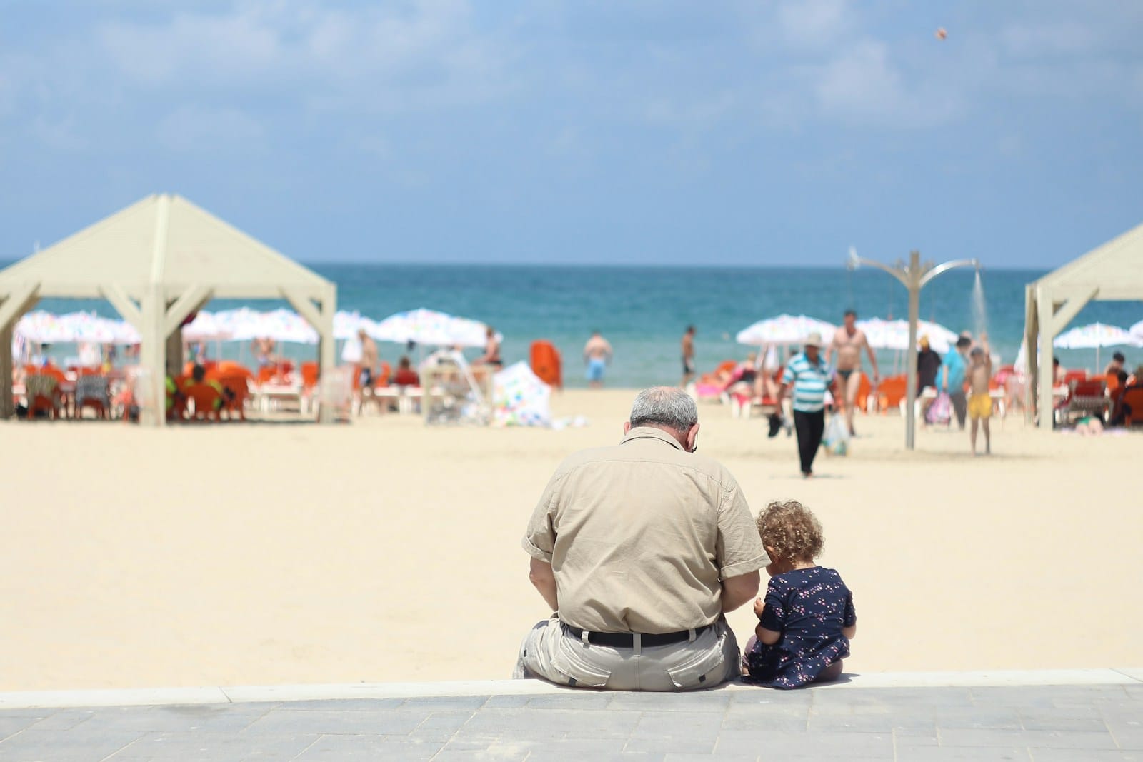 man sitting besides girl on bench